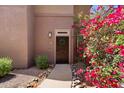 Exterior view of front door with wreath and colorful bougainvillea at 19777 N 76Th St # 1106, Scottsdale, AZ 85255