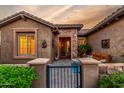 Charming front entrance with stone accents, gated courtyard, and desert landscaping at 20558 N 263Rd Dr, Buckeye, AZ 85396