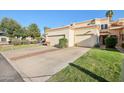 Single story home featuring a well-manicured lawn, mature trees, and a two-car garage at 250 W Juniper Ave # 22, Gilbert, AZ 85233