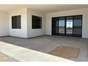 A spacious covered patio with a concrete floor, black trimmed windows and door providing natural light and outdoor living at 31060 N 213Th Dr, Wittmann, AZ 85361