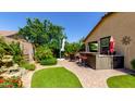 Private backyard oasis with a built-in bar, patio seating, green lawn, and lush landscaping at 3578 E Walnut Rd, Gilbert, AZ 85298