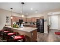 Spacious kitchen with stainless steel appliances, a breakfast bar, and warm pendant lighting at 3578 E Walnut Rd, Gilbert, AZ 85298