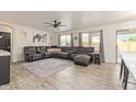 Spacious living room featuring a large sectional sofa, modern ceiling fan, and wood-look flooring at 38659 N Alamo Ct, San Tan Valley, AZ 85140