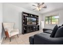 Comfortable living room features a large TV, modern entertainment center, and neutral decor at 39959 W Williams Way, Maricopa, AZ 85138