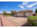 A home with a large three-car garage and manicured landscaping, complete with desert-style greenery at 4055 N Recker Rd # 62, Mesa, AZ 85215