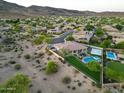 Aerial view showing a large home with a pool, basketball court, mature trees, and desert surroundings at 4417 W El Cortez Trl, Phoenix, AZ 85083