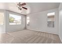 Spacious living room with ample natural light, carpet flooring, and neutral walls, perfect for relaxing at 45018 W Sage Brush Dr, Maricopa, AZ 85139