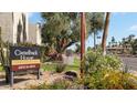 A sign for Camelback House Condominiums, surrounded by colorful flowers and lush greenery at 4630 N 68Th St # 265, Scottsdale, AZ 85251