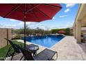 Relax by the custom pool and spa with a red umbrella, and a green lawn, offering a peaceful backyard retreat at 5621 E Lonesome Trl, Cave Creek, AZ 85331