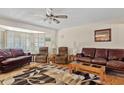 Spacious living room with hardwood floors, neutral walls, ceiling fan, and comfortable seating with natural light at 6237 E Boston St, Mesa, AZ 85205