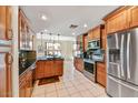 Well-equipped kitchen with stainless steel appliances, wood cabinets, and sleek countertops at 7700 E Gainey Ranch Rd # 124, Scottsdale, AZ 85258