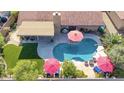 Aerial view of a backyard featuring a pool, patio, and green turf, ideal for entertaining at 13533 N 91St Way, Scottsdale, AZ 85260