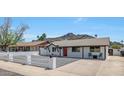 Beautifully maintained single-story home showcasing a bright red front door, rock driveway, and a charming curb appeal at 1511 E Carol Ave, Phoenix, AZ 85020