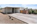Wide driveway with carport and small shrubs in gravel yard at 1641 S Sossaman Rd, Mesa, AZ 85209