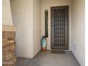 Close-up of the secure front door with a decorative storm door and tiled entryway at 16466 W Lariat Ln, Surprise, AZ 85387