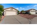 A well maintained single-story home featuring a neutral-toned exterior, desert landscaping, and a two-car garage at 20717 N 104Th Ln, Peoria, AZ 85382