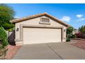 A well maintained single-story home featuring a neutral-toned exterior, desert landscaping, and a two-car garage at 20717 N 104Th Ln, Peoria, AZ 85382
