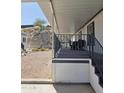 A covered patio with stairs leading down to a gravel yard area at 2233 E Behrend Dr # 211, Phoenix, AZ 85024