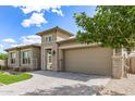 Single-story home with attached two-car garage, stone accents, and paved driveway and walkway at 22825 E Mewes Rd, Queen Creek, AZ 85142