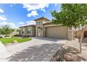 A single story home with lush green grass, decorative trees, and a paved driveway at 22825 E Mewes Rd, Queen Creek, AZ 85142