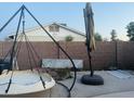 A backyard featuring a hanging egg chair, patio umbrella, and brick wall fence at 2459 E Baltimore St, Mesa, AZ 85213