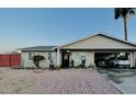 Charming home featuring a covered driveway, desert landscaping, and mature palm trees at 2459 E Baltimore St, Mesa, AZ 85213