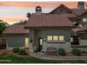 Charming home with a red tile roof, manicured lawn, and inviting blue front door at sunset at 2801 N Litchfield Rd # 37, Goodyear, AZ 85395