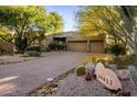 Attractive home featuring desert landscaping and a large driveway leading to a two-car garage at 29412 N 108Th Pl, Scottsdale, AZ 85262