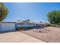 Lovely single-story home featuring a garage, driveway, desert landscaping, and a blue exterior at 3109 N 81St St, Scottsdale, AZ 85251