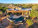 Aerial view of a luxurious home with a private pool, patio, and stunning desert surroundings at 39810 N 105Th Way # 128, Scottsdale, AZ 85262