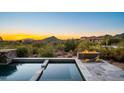 Relaxing poolside view with a stone fire pit and mountain backdrop, perfect for evening relaxation at 39810 N 105Th Way # 128, Scottsdale, AZ 85262