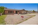 Charming brick home with covered parking and a spacious front yard under a bright sky at 4349 W Morten Ave, Glendale, AZ 85301