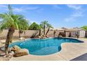 Beautiful backyard pool with rock features, palm trees, waterfall feature and diving board for summer fun at 5046 W Monte Cristo Ave, Glendale, AZ 85306