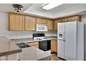 Practical kitchen featuring wood cabinetry, a double sink, and white appliances at 537 S Delaware Dr # 224, Apache Junction, AZ 85120