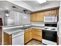 Functional kitchen with wood cabinets, white appliances, and laminate countertops at 537 S Delaware Dr # 224, Apache Junction, AZ 85120