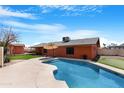 Sparkling swimming pool in a private backyard with a patio umbrella for relaxing on sunny days at 654 W Plata Ave, Mesa, AZ 85210