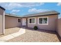 Home exterior showcasing a walkway, desert landscaping, and neutral color scheme, creating a welcoming curb appeal at 7045 S 42Nd St, Phoenix, AZ 85042