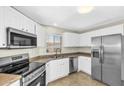 Bright kitchen featuring stainless steel appliances, tiled floors, and white cabinetry at 7045 S 42Nd St, Phoenix, AZ 85042