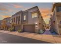 Modern townhome exterior featuring a two-car garage, desert landscaping, and a sleek architectural design at 7464 E Paraiso Dr, Scottsdale, AZ 85255