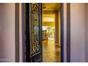Elegant entryway featuring an ornate iron door, hardwood floors, and a view of the backyard at 9059 E Leonora St. St, Mesa, AZ 85207