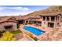 Stunning aerial view of a desert home featuring a private pool, patio, and lush desert landscaping at 9820 E Thompson Peak Pkwy # 628, Scottsdale, AZ 85255
