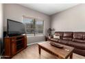 Cozy living room featuring a comfortable leather sofa and natural light at 10030 W Indian School Rd # 165, Phoenix, AZ 85037