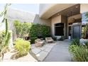 Inviting courtyard with cozy seating area, lush greenery, and a stone-paved walkway to the entrance at 10795 E Sutherland Way, Scottsdale, AZ 85262