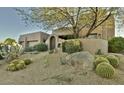 Southwest style home featuring lush desert landscaping and a rock garden at the entrance with cactus at 10795 E Sutherland Way, Scottsdale, AZ 85262