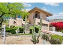 Beautiful home with landscaped front yard, cacti, rock features and a two-car garage at 12 E Foothill Dr, Phoenix, AZ 85020