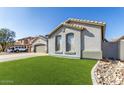 Side view of the home showing two large windows and well maintained green lawn at 13628 W San Miguel Ave, Litchfield Park, AZ 85340