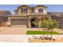 Charming two-story home showcasing stone accents, a two-car garage, and well-manicured landscaping at 15626 W Georgia Dr, Surprise, AZ 85379