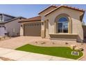 Single-story home with red tile roof, two-car garage, desert landscaping, and brick paved driveway at 15796 W Georgia W Dr, Surprise, AZ 85379