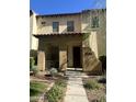 Inviting two-story home with a covered entrance, number visible, and lush greenery at 21166 W Main St, Buckeye, AZ 85396