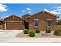 Charming single-story home features a two-car garage, manicured desert landscaping, and a stone front accent at 24327 N 163Rd Dr, Surprise, AZ 85387